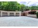 A three car garage and entry of home with fresh gravel and red roof stand nestled in a lush forest at 382 Valley Ln, Pittsboro, NC 27312