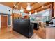 Open kitchen boasts a large island with seating, wood ceiling, and modern lighting fixtures at 382 Valley Ln, Pittsboro, NC 27312