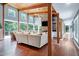 Bright living room with wood ceiling, stone fireplace, hardwood floors and large picture windows at 382 Valley Ln, Pittsboro, NC 27312