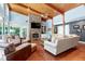 A luxurious living room with stone fireplace, wood ceilings and floors with modern furnishings at 382 Valley Ln, Pittsboro, NC 27312