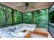 Cozy screened-in porch with comfortable seating and a peaceful view of the surrounding trees at 382 Valley Ln, Pittsboro, NC 27312