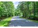 Tree lined street with lush green lawn and privacy wall at 382 Valley Ln, Pittsboro, NC 27312