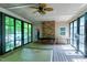 Enclosed sunroom features stone fireplace, ceiling fan, and access to a pool or hot tub at 382 Valley Ln, Pittsboro, NC 27312
