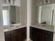A bathroom featuring double sinks with modern fixtures and dark wood cabinets at 3920 Well Fleet Dr, Fuquay Varina, NC 27526