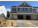 New construction townhouse with gray siding, decorative shutters, and an attached two-car garage at 3924 Well Fleet Dr, Fuquay Varina, NC 27526