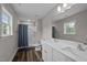 Bathroom features a double sink vanity, a toilet, and shower-tub with a blue shower curtain at 412 Carr Store Rd, Cedar Grove, NC 27231