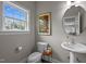 Powder bathroom features pedestal sink, modern fixtures, and neutral paint palette at 412 Carr Store Rd, Cedar Grove, NC 27231
