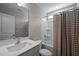 Bathroom features a single sink vanity, a toilet, and shower-tub with patterned shower curtain at 412 Carr Store Rd, Cedar Grove, NC 27231