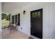 Inviting covered porch with seating, black door, and white vertical siding for a cozy curb appeal at 412 Carr Store Rd, Cedar Grove, NC 27231