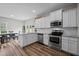 Bright kitchen boasts stainless appliances, granite countertops, white cabinetry, and open dining area at 412 Carr Store Rd, Cedar Grove, NC 27231