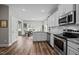 Bright kitchen opens to dining area and boasts stainless appliances, granite counters, and white cabinetry at 412 Carr Store Rd, Cedar Grove, NC 27231