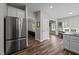 Stainless steel refrigerator in kitchen opens to dining and living areas with wood-look floors at 412 Carr Store Rd, Cedar Grove, NC 27231