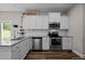 Bright kitchen features stainless appliances, granite countertops, white cabinetry, and modern tile backsplash at 412 Carr Store Rd, Cedar Grove, NC 27231