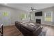 Bright living room featuring a fireplace, large windows, ceiling fan, and hardwood flooring at 412 Carr Store Rd, Cedar Grove, NC 27231