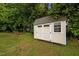 Outdoor storage shed with double doors and a window at 412 Carr Store Rd, Cedar Grove, NC 27231