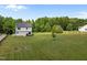 Large backyard showcasing a well-manicured lawn with the home at the center, offering ample space at 412 Carr Store Rd, Cedar Grove, NC 27231