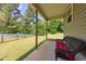 Relaxing covered porch with outdoor seating overlooks a spacious backyard with lawn and trees at 50 Viajar Way, Smithfield, NC 27577