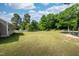 Large backyard with a wooden fence and mature trees on a sunny day at 50 Viajar Way, Smithfield, NC 27577