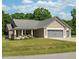 Charming tan home with a two car garage and a rocking chair front porch at 50 Viajar Way, Smithfield, NC 27577