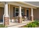 Inviting front porch with rocking chairs, stone pillars, and a dark front door at 50 Viajar Way, Smithfield, NC 27577