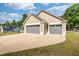 Three-car garage with a large concrete driveway and partial lawn at 50 Viajar Way, Smithfield, NC 27577