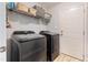 Functional laundry room with modern washer and dryer units, plus shelving for storage at 50 Viajar Way, Smithfield, NC 27577