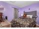 Comfortable bedroom with a floral-patterned bedspread and purple walls at 505 Stratton Way, Durham, NC 27704