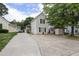 Traditional two-story home with light beige siding and a long driveway, complemented by lush green trees at 505 Stratton Way, Durham, NC 27704