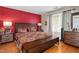 Cozy bedroom featuring hardwood floors and a decorative red accent wall at 505 Stratton Way, Durham, NC 27704