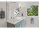 Bright bathroom with a double sink vanity, modern fixtures, and a diamond-pane window at 5308 Montclair Dr, Raleigh, NC 27609