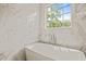 Bright bathroom with a soaking tub under a large window with natural light at 5308 Montclair Dr, Raleigh, NC 27609