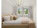 Bright bedroom featuring a statement light fixture, plush bed, and natural light from the double windows at 5308 Montclair Dr, Raleigh, NC 27609