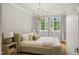 Bright bedroom featuring a statement light fixture, plush bed, night stands and natural light from the windows at 5308 Montclair Dr, Raleigh, NC 27609
