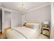 Bright bedroom featuring a statement light fixture, plush bed, night stands and natural light from the windows at 5308 Montclair Dr, Raleigh, NC 27609