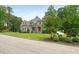 Elegant two-story home with lush front lawn and mature trees providing privacy at 5308 Montclair Dr, Raleigh, NC 27609