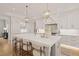 Bright kitchen with a large island and barstool seating, quartz countertops and stylish lighting at 5308 Montclair Dr, Raleigh, NC 27609