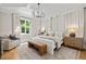 Luxurious main bedroom with a tray ceiling, elegant chandelier, hardwood floors, and large windows at 5308 Montclair Dr, Raleigh, NC 27609