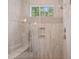 Detailed view of the stylishly tiled shower with a glass enclosure and a window at 5308 Montclair Dr, Raleigh, NC 27609