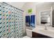 A modern bathroom features a colorful shower curtain, a sink, and decorative elements for a fresh look at 5412 Emerald Spring Dr, Knightdale, NC 27545