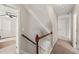 An inviting hallway with wood railing stairs that lead to bedrooms, with an open doorway to a bedroom at 5412 Emerald Spring Dr, Knightdale, NC 27545