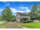 Spacious backyard with lush lawn, mature trees, screened-in porch, and pool area at 5521 Erinvale Ct, Holly Springs, NC 27540
