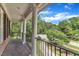 Balcony with white columns and black iron railing, providing a serene outdoor space with lush greenery views at 5521 Erinvale Ct, Holly Springs, NC 27540