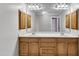 Dual vanities, wood cabinets, and a large mirror provide both functionality and style in this bathroom at 5521 Erinvale Ct, Holly Springs, NC 27540