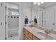 Bright bathroom featuring a single vanity and tub, with neutral tiling and ample storage at 5521 Erinvale Ct, Holly Springs, NC 27540