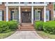 Welcoming front entrance with a classic brick facade, elegant columns, and beautifully landscaped surroundings at 5521 Erinvale Ct, Holly Springs, NC 27540