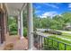 Inviting front porch with decorative columns and a black metal railing overlooks a lush, green landscape at 5521 Erinvale Ct, Holly Springs, NC 27540