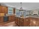 Charming kitchen with wood cabinets, granite counters, and stainless steel dishwasher flows into the sun-drenched breakfast area at 5521 Erinvale Ct, Holly Springs, NC 27540