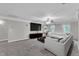 Spacious living room with large sectional sofa, ceiling fan, and entertainment center at 5521 Erinvale Ct, Holly Springs, NC 27540