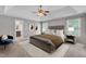 Neutral color scheme, a large bed, and a sitting chair highlight this bedroom's comfort at 5521 Erinvale Ct, Holly Springs, NC 27540