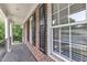 Inviting brick porch featuring black shutters, white columns, and verdant views at 5521 Erinvale Ct, Holly Springs, NC 27540